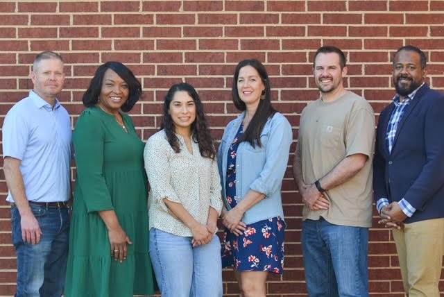 The Echo Mentoring board of directors standing together in front of a brick wall